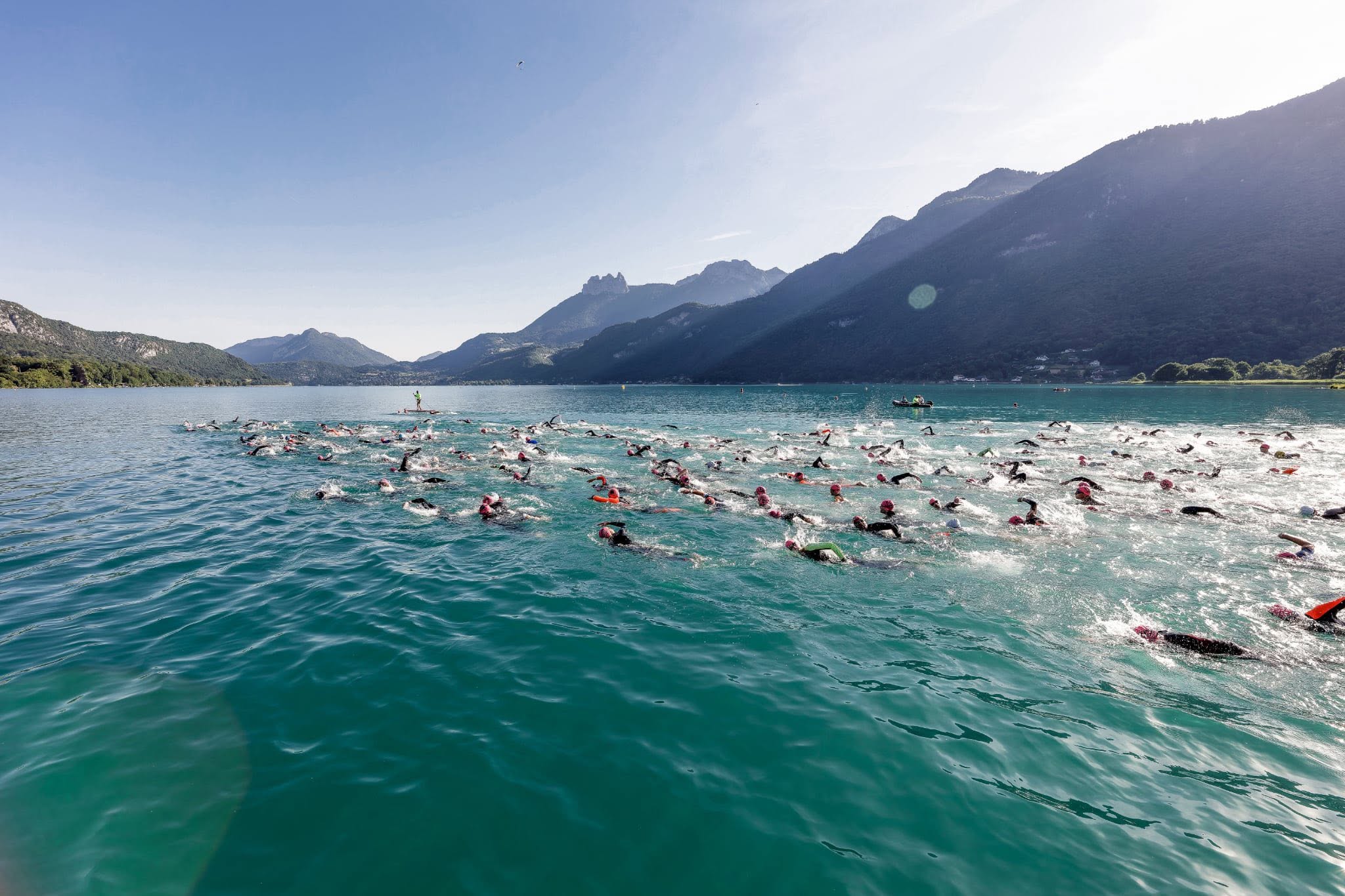 Nageurs en groupe dans un lac au pied des montagnes